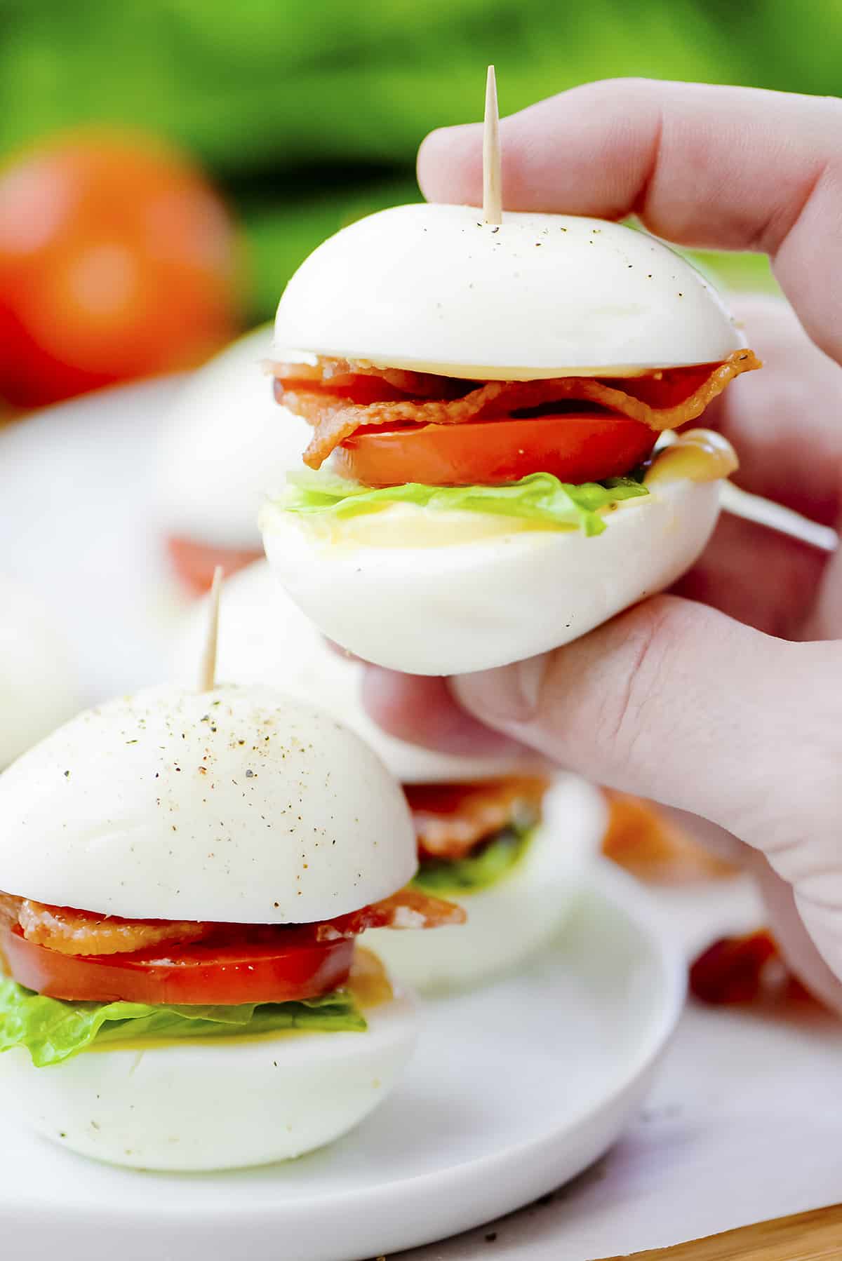 Hand holding a boiled egg BLT.