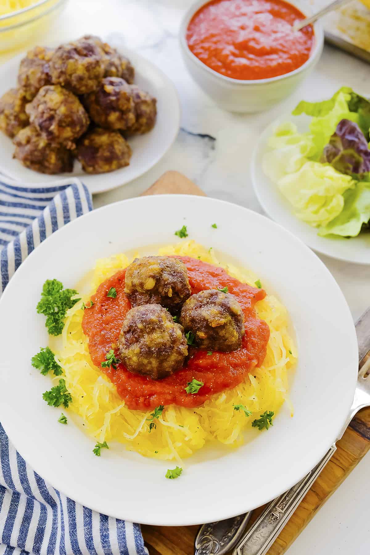 Spaghetti squash and meatballs on white plate.