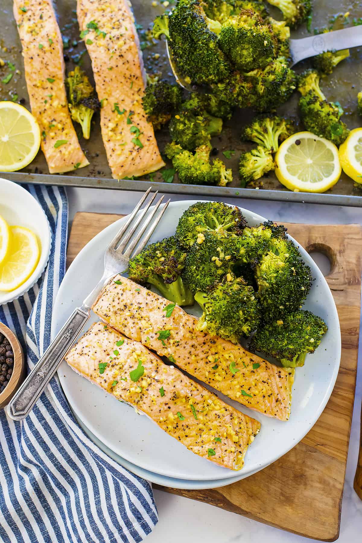 Overhead view of lemon pepper salmon and broccoli on plate.