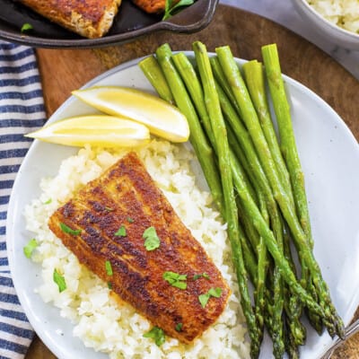 Overhead view of blackened mahi mahi on plate with cauliflower rice and asparagus.