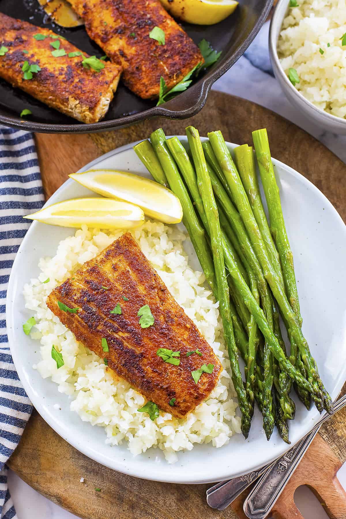 Overhead view of blackened mahi mahi on plate with cauliflower rice and asparagus.