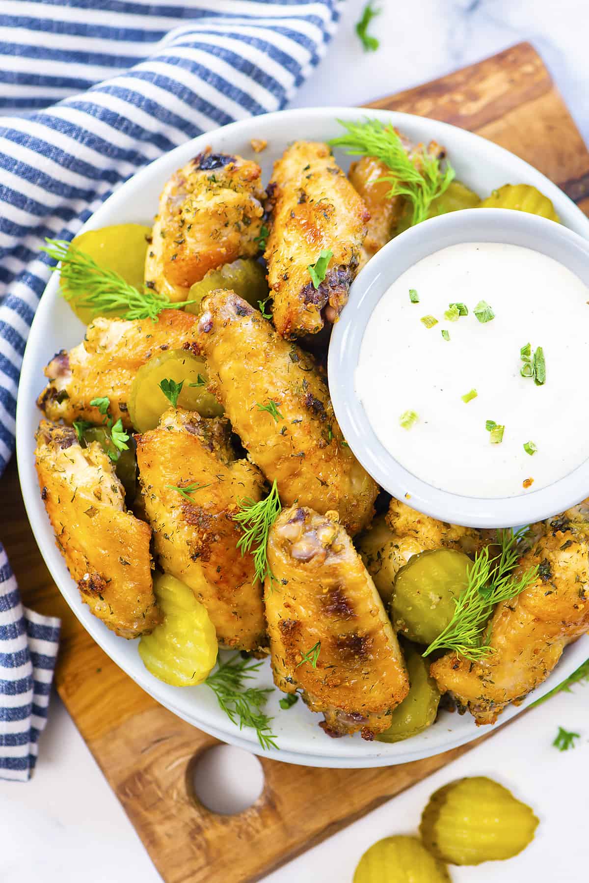Dill pickle chicken wings with ranch in white bowl.
