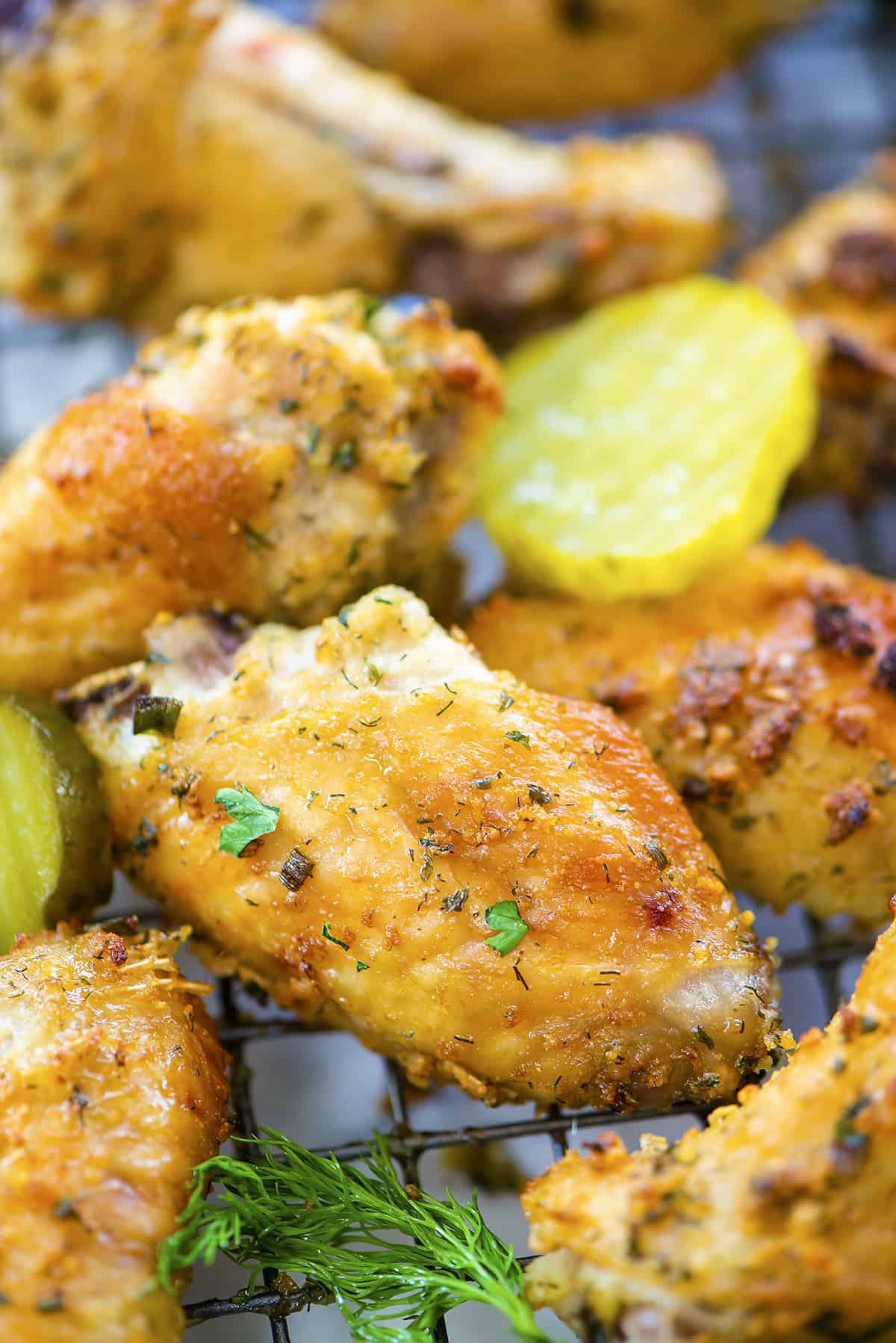 Close up of ranch chicken wings with pickles.