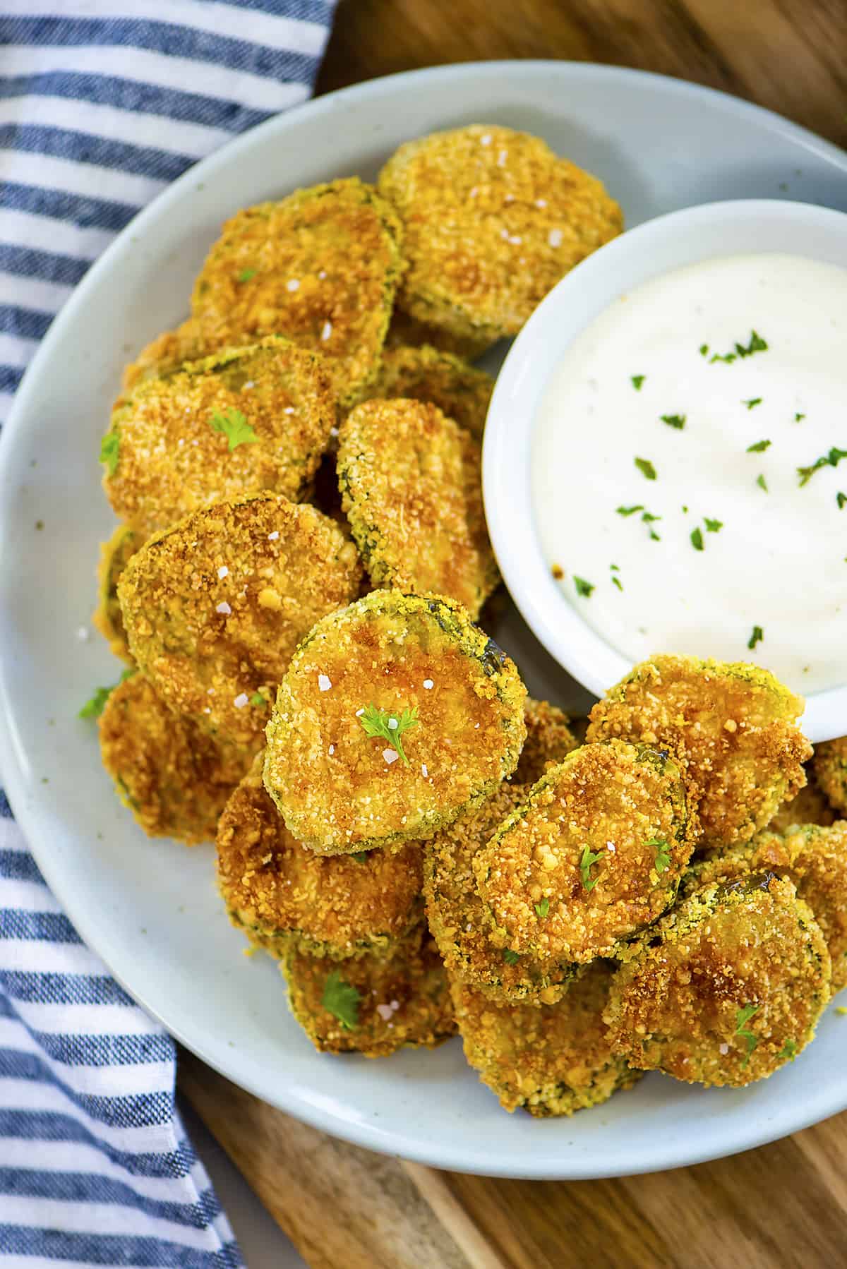 Overhead view of fried pickles in bowl with ranch.
