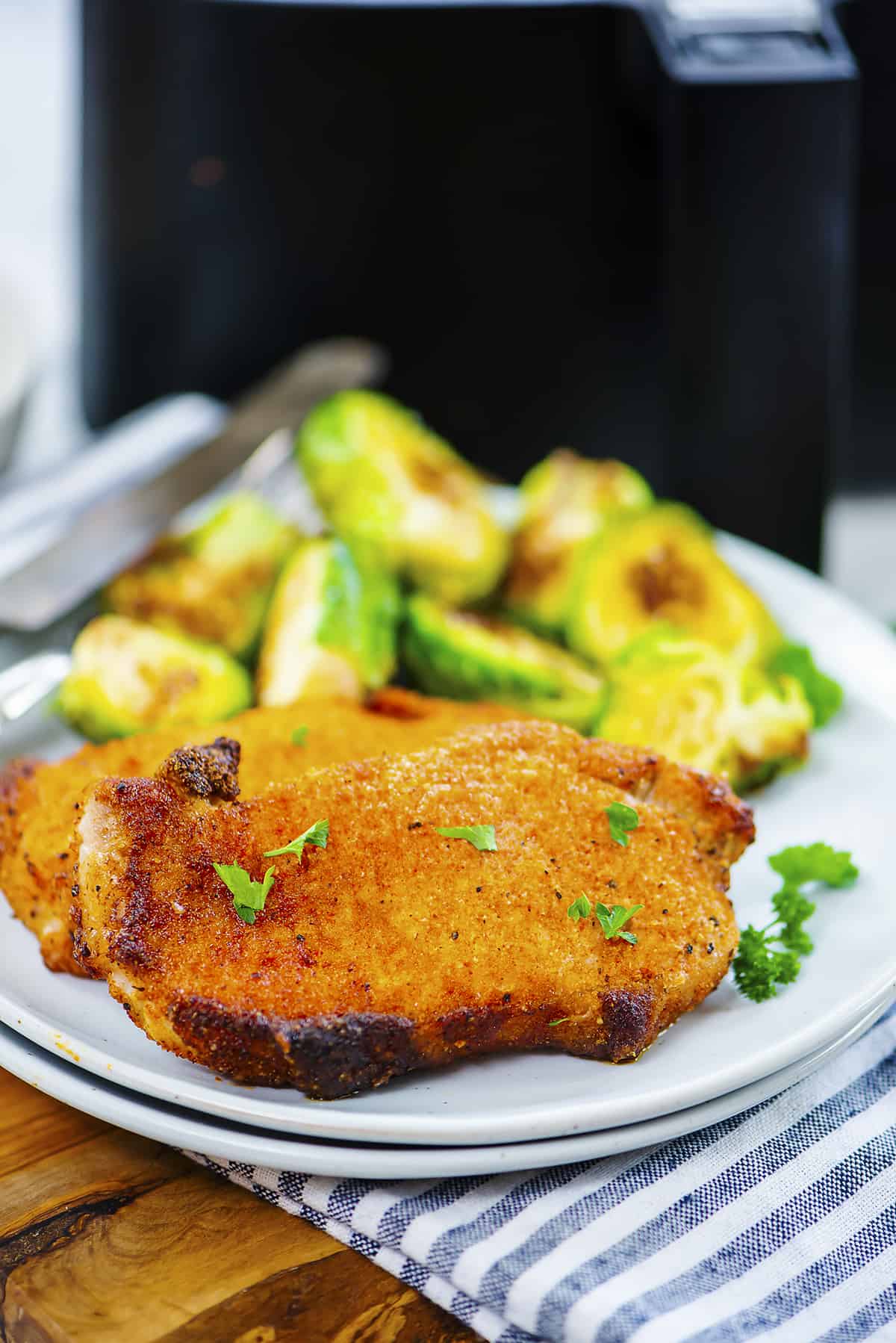 Pork chops on plate with Brussels sprouts.