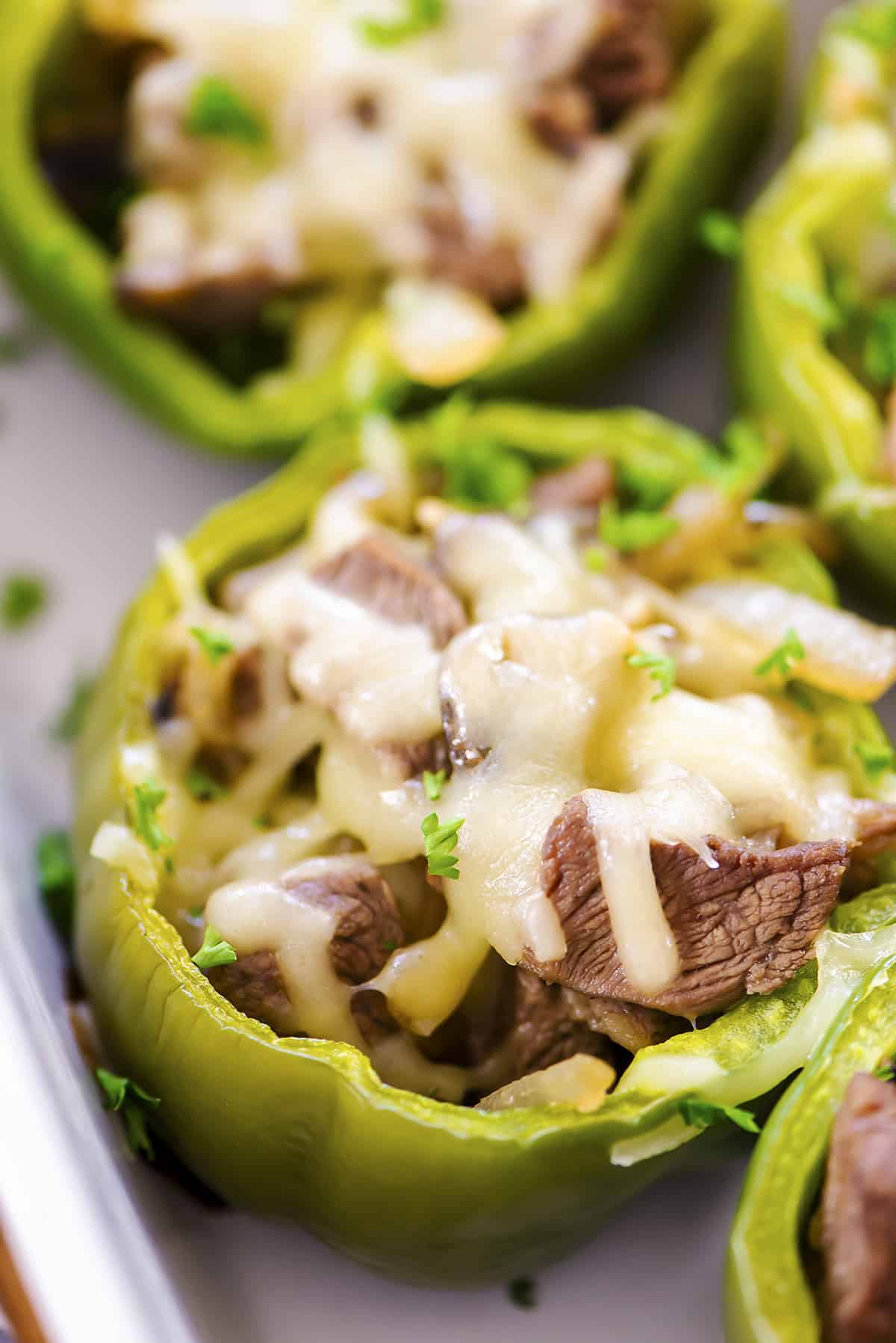 Philly cheesesteak stuffed pepper in white baking dish.