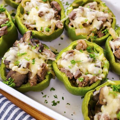 Philly cheesesteak stuffed peppers in white baking dish.