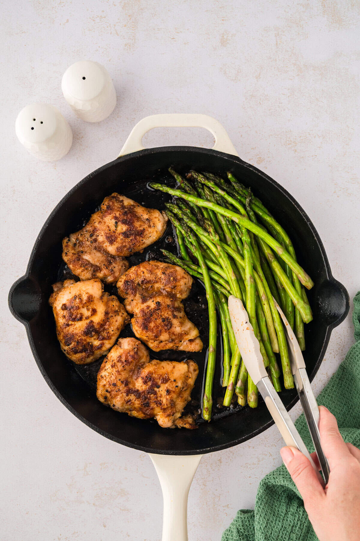 Asparagus being cooked in pan with chicken.