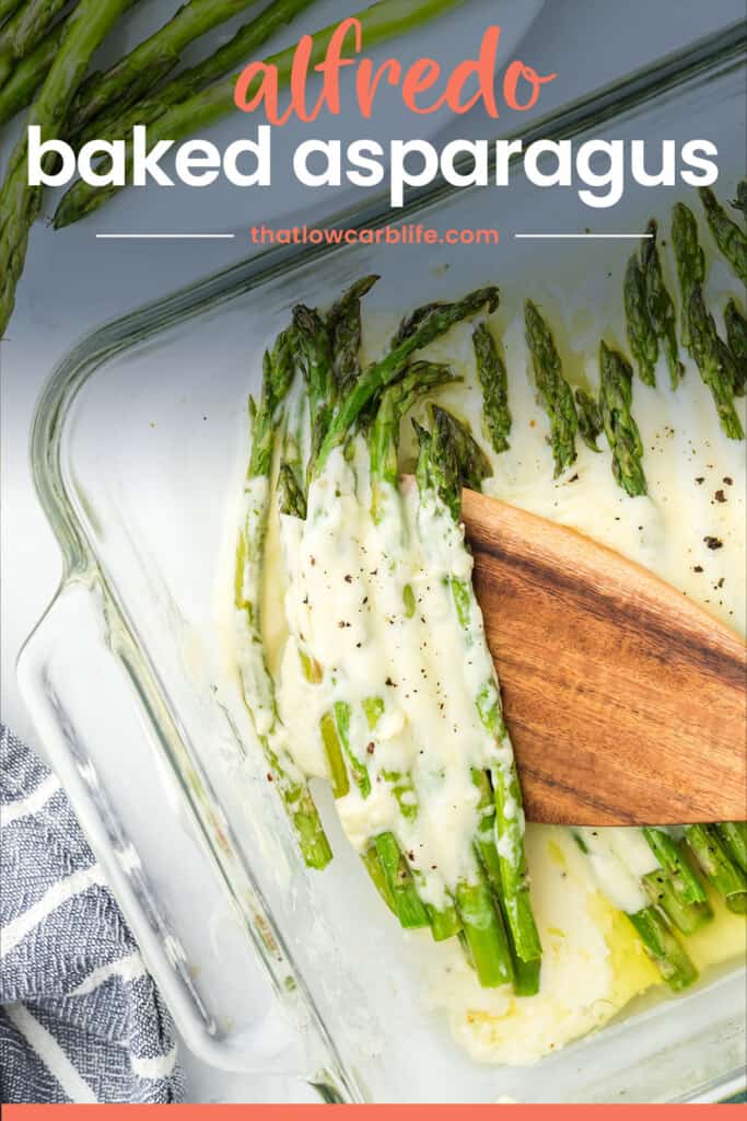 Asparagus and alfredo sauce in baking dish.