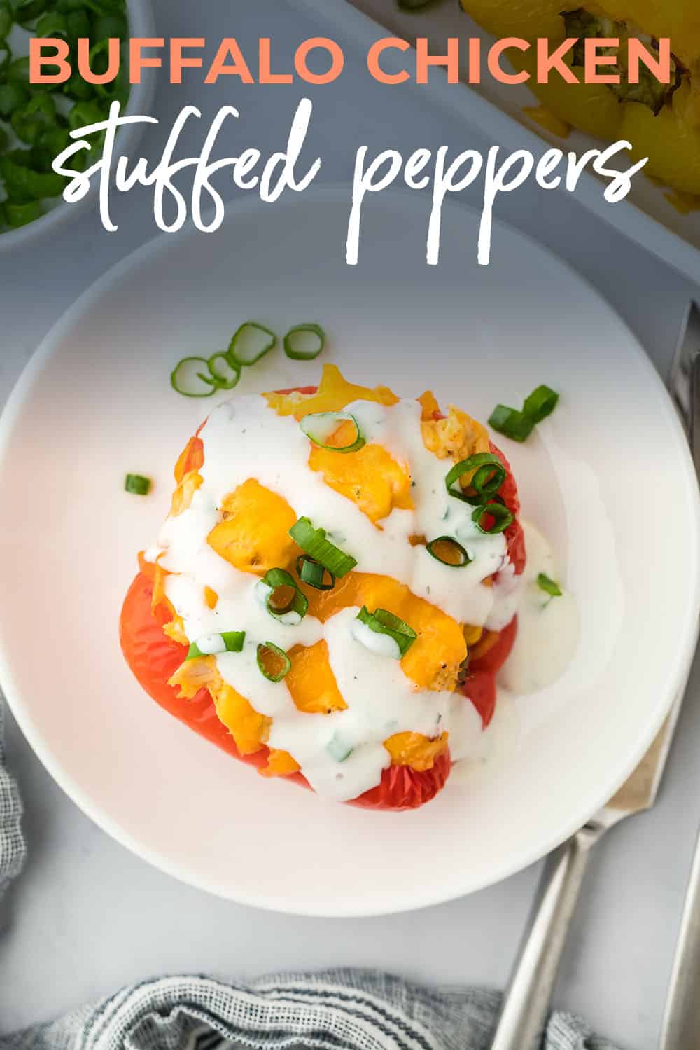 Buffalo chicken stuffed pepper on white plate with ranch dressing.