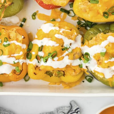 Buffalo chicken stuffed peppers drizzled with ranch dressing.