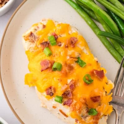 Baked crack chicken on plate with green beans.