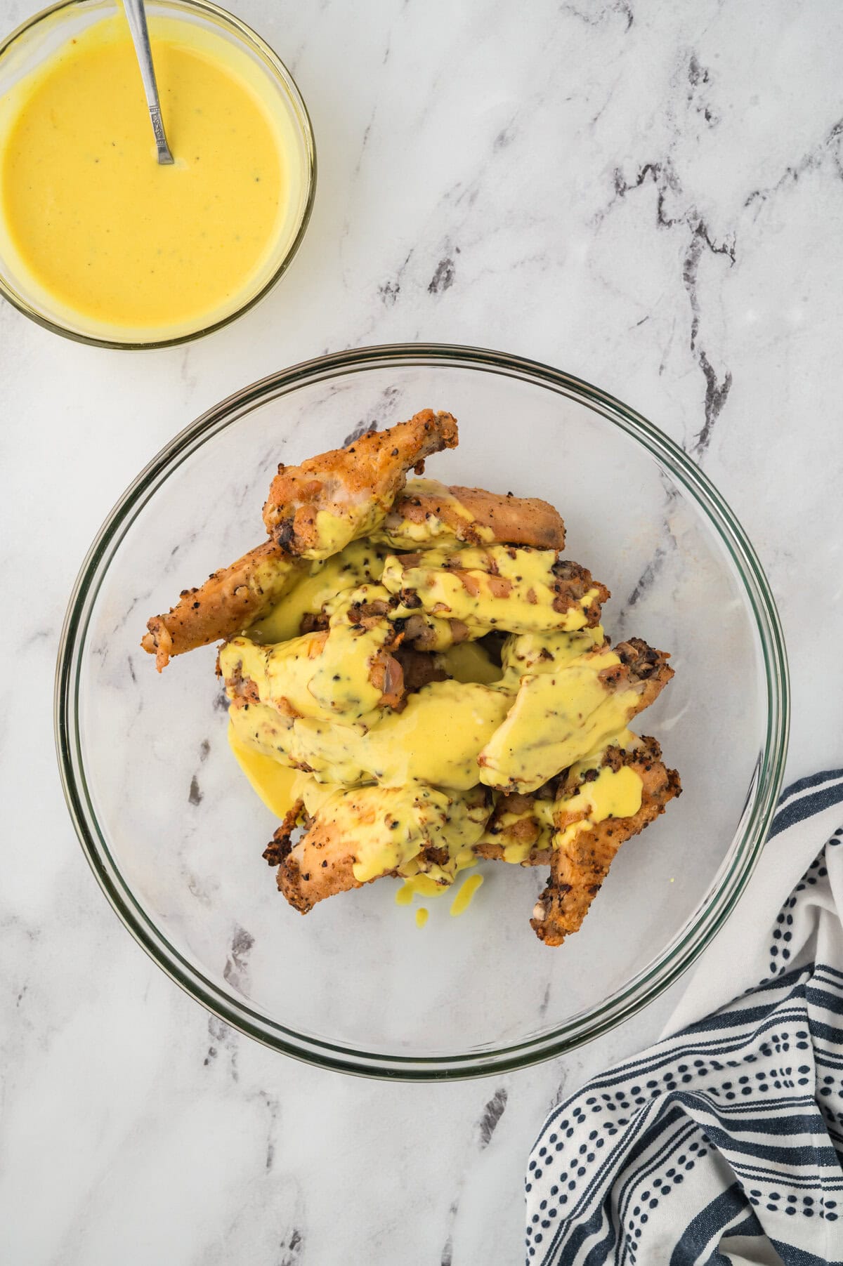 Crispy baked wings being tossed in honey mustard.
