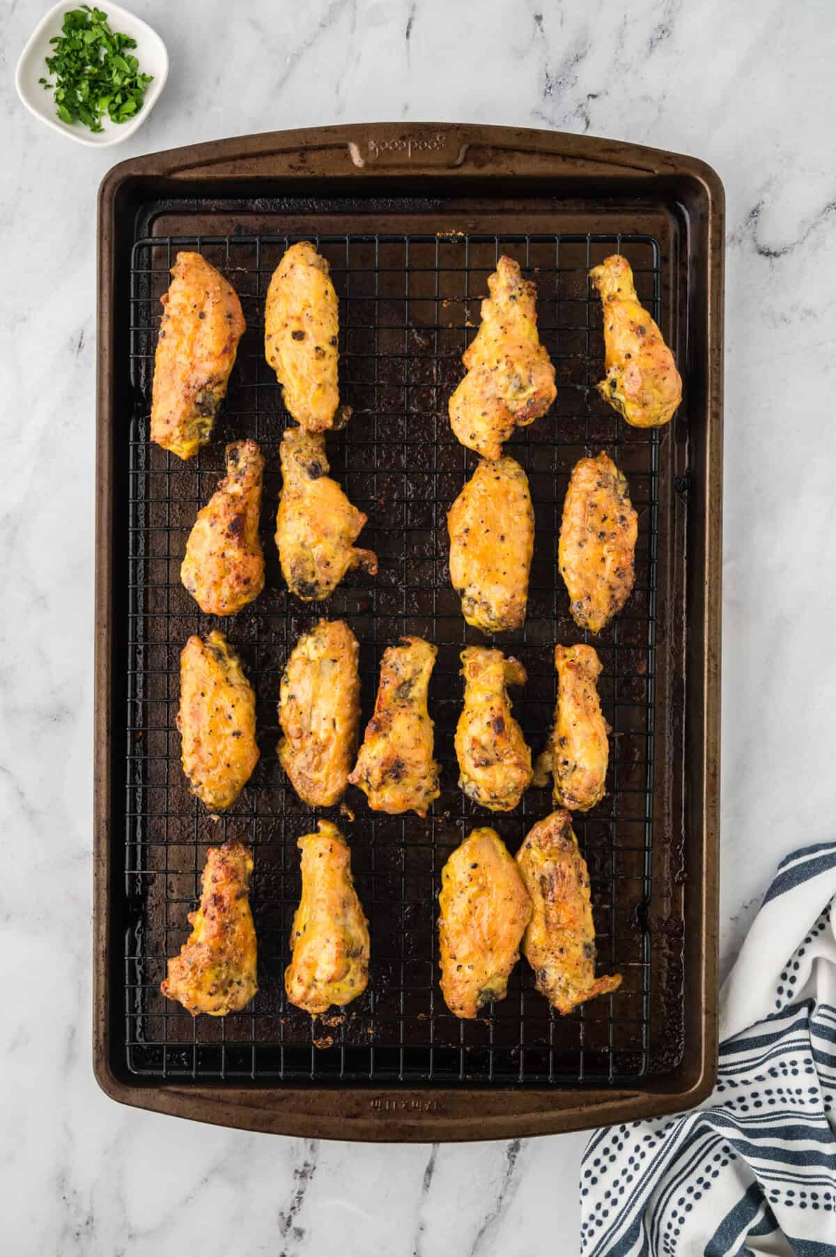 Sauced wings being baked on sheet pan.