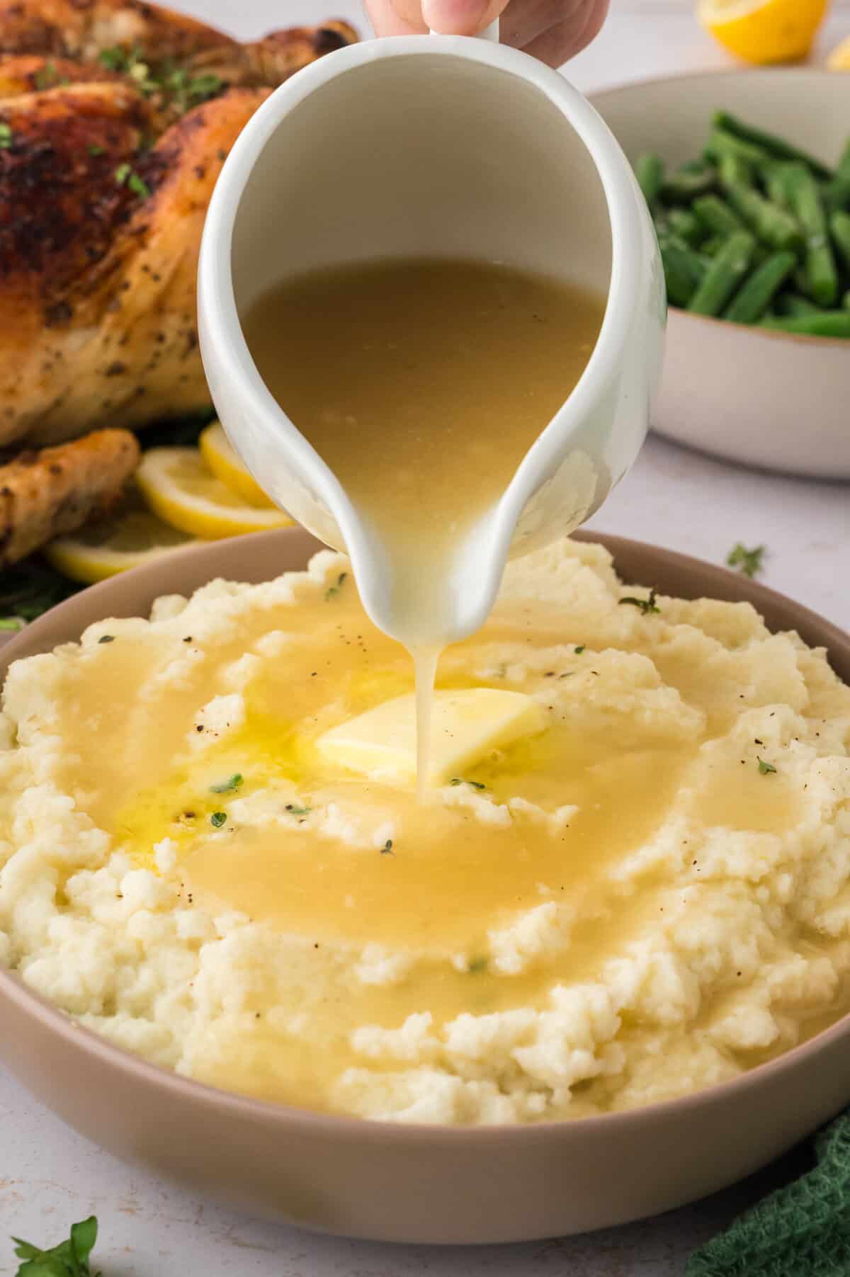 Keto gravy being poured over mashed cauliflower.
