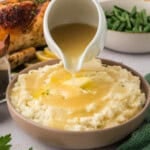 Keto gravy being poured over mashed cauliflower.