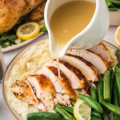 Low carb gravy being drizzled over roasted turkey and mashed cauliflower.