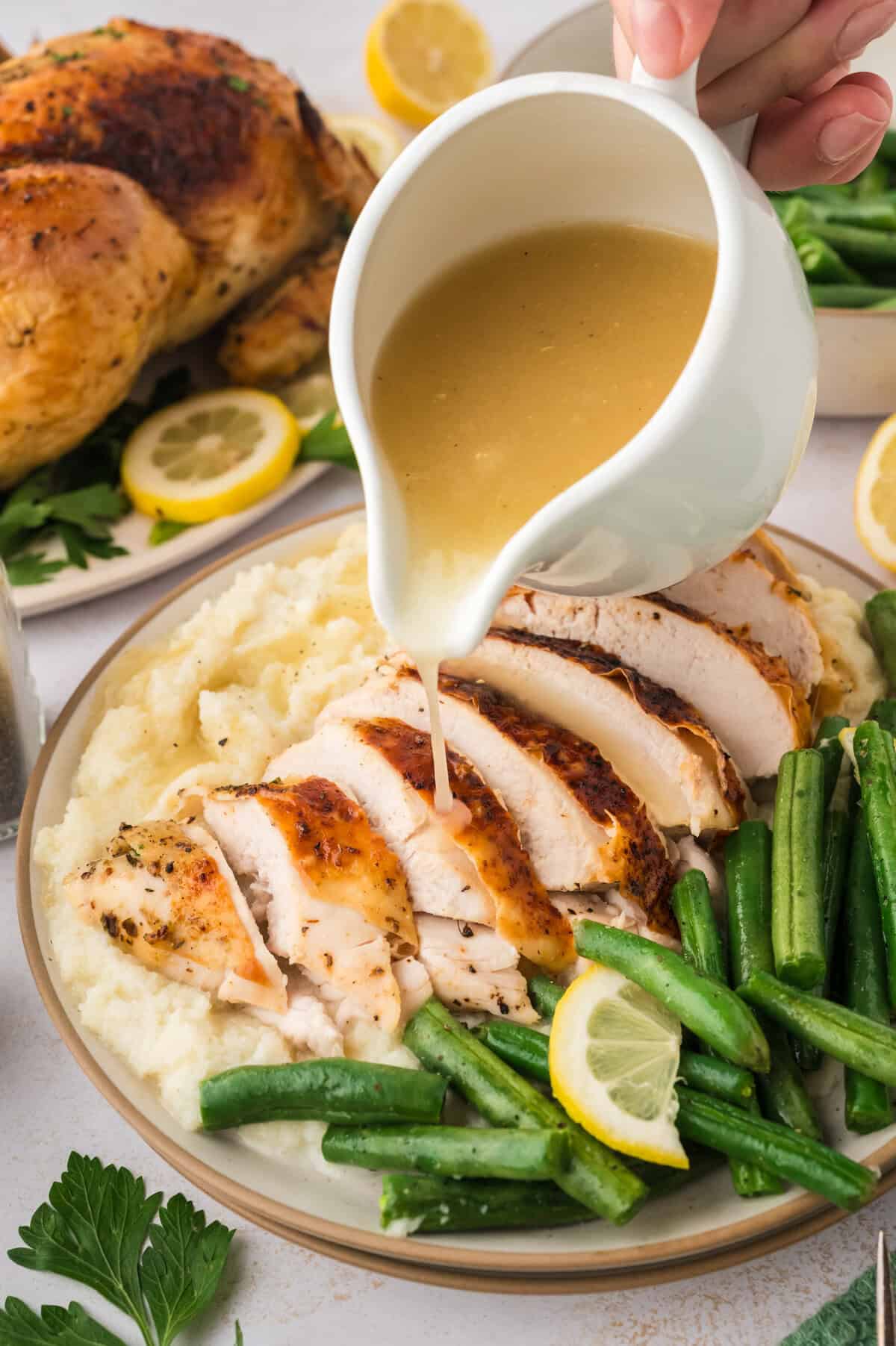 Low carb gravy being drizzled over roasted turkey and mashed cauliflower.