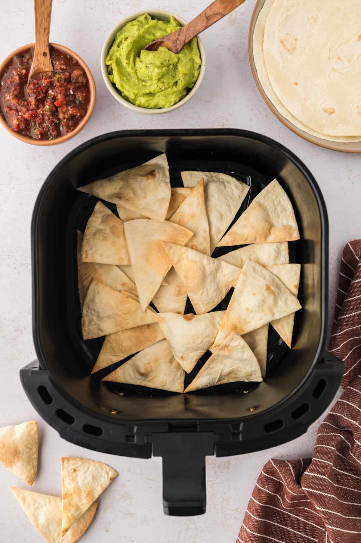 Keto tortilla chips in air fryer basket.