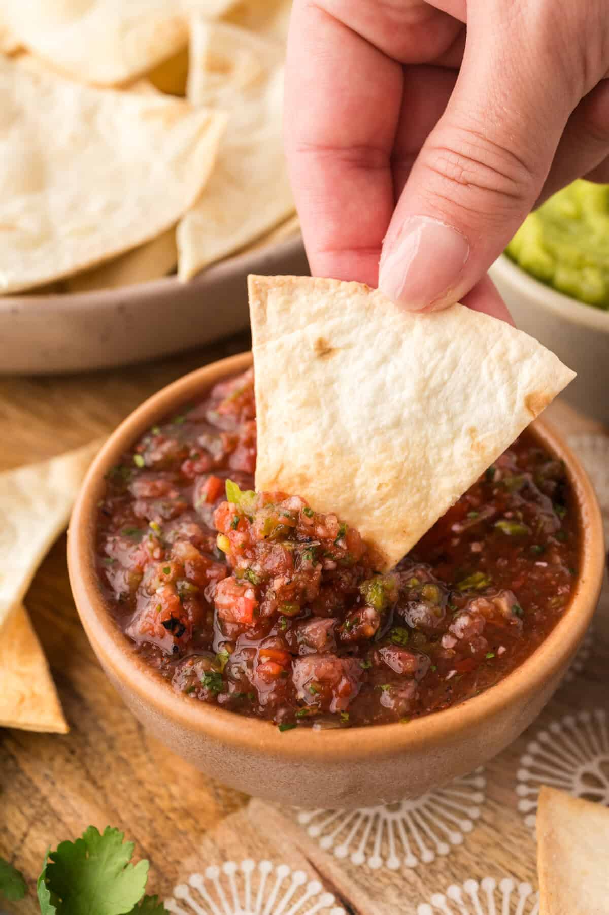 Keto tortilla chip being dipped in salsa.