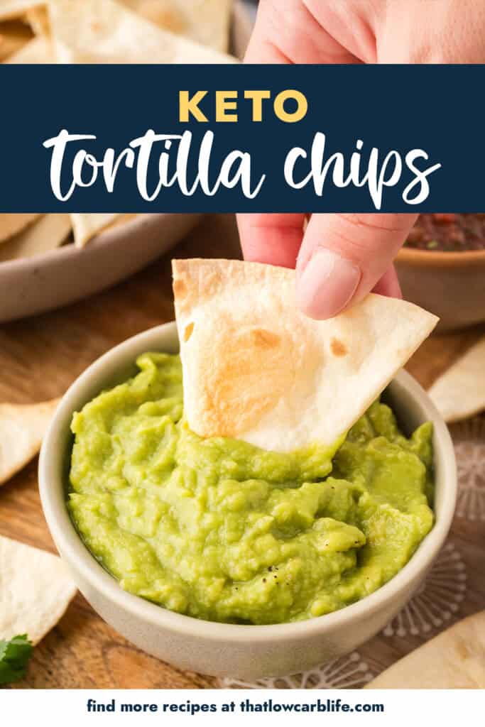 Low carb tortilla chip being dipped in guacamole.