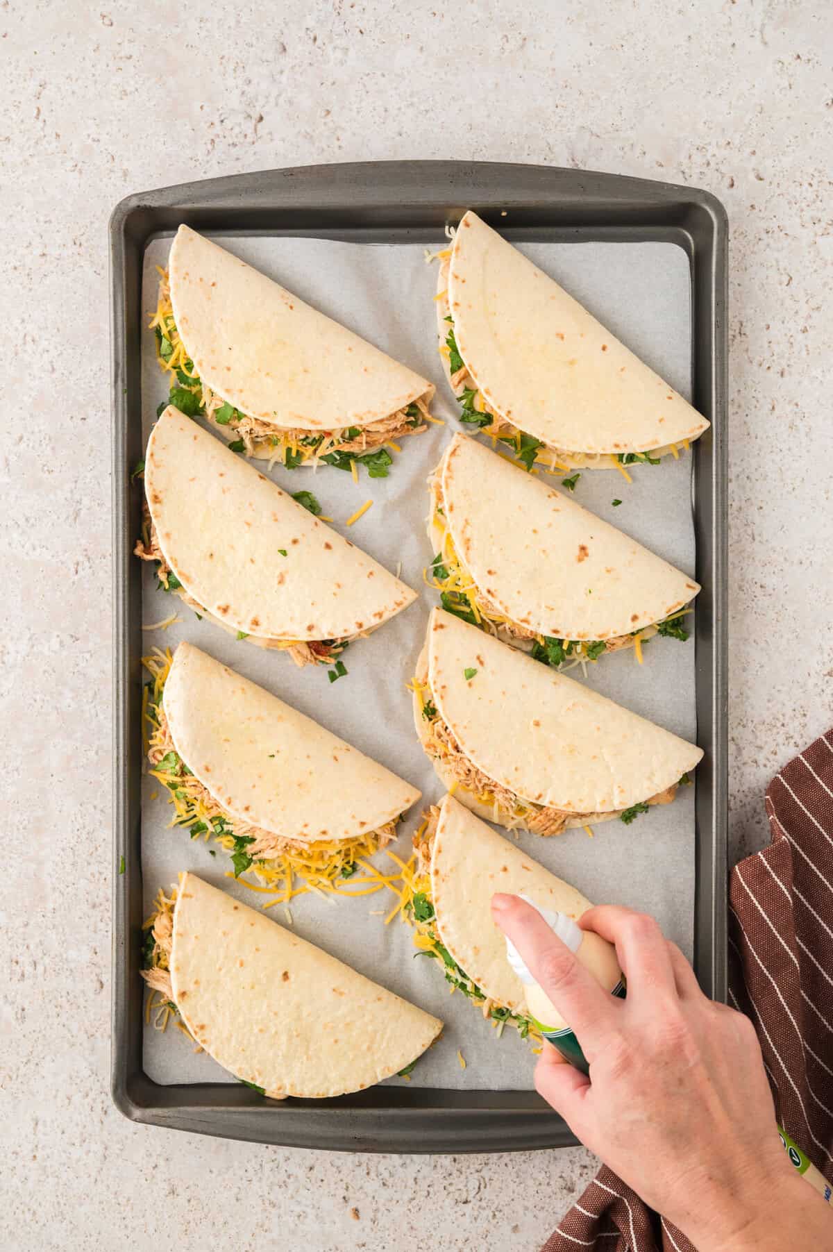 Oil being sprayed on tacos.