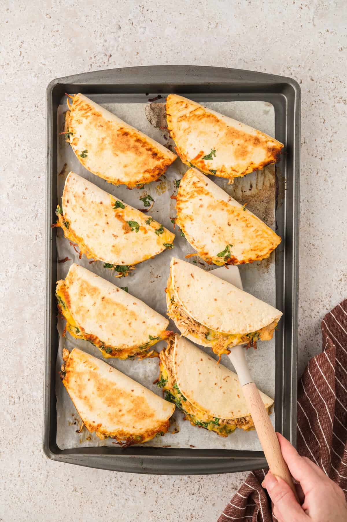 Tacos being flipped over with spatula.