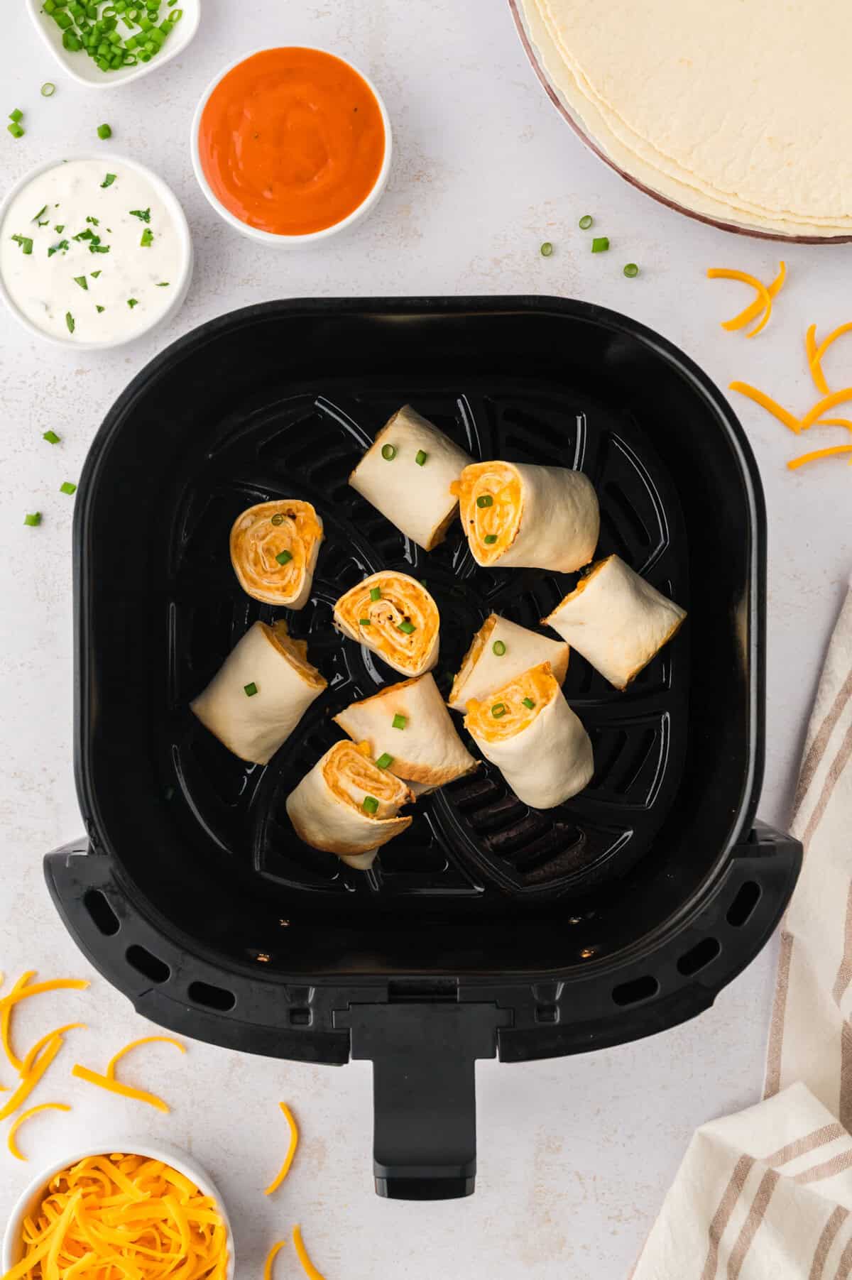 Crispy buffalo chicken pinwheels in air fryer.