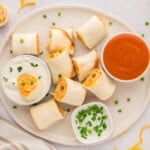 Buffalo chicken pinwheels on plate with ranch and buffalo sauce.