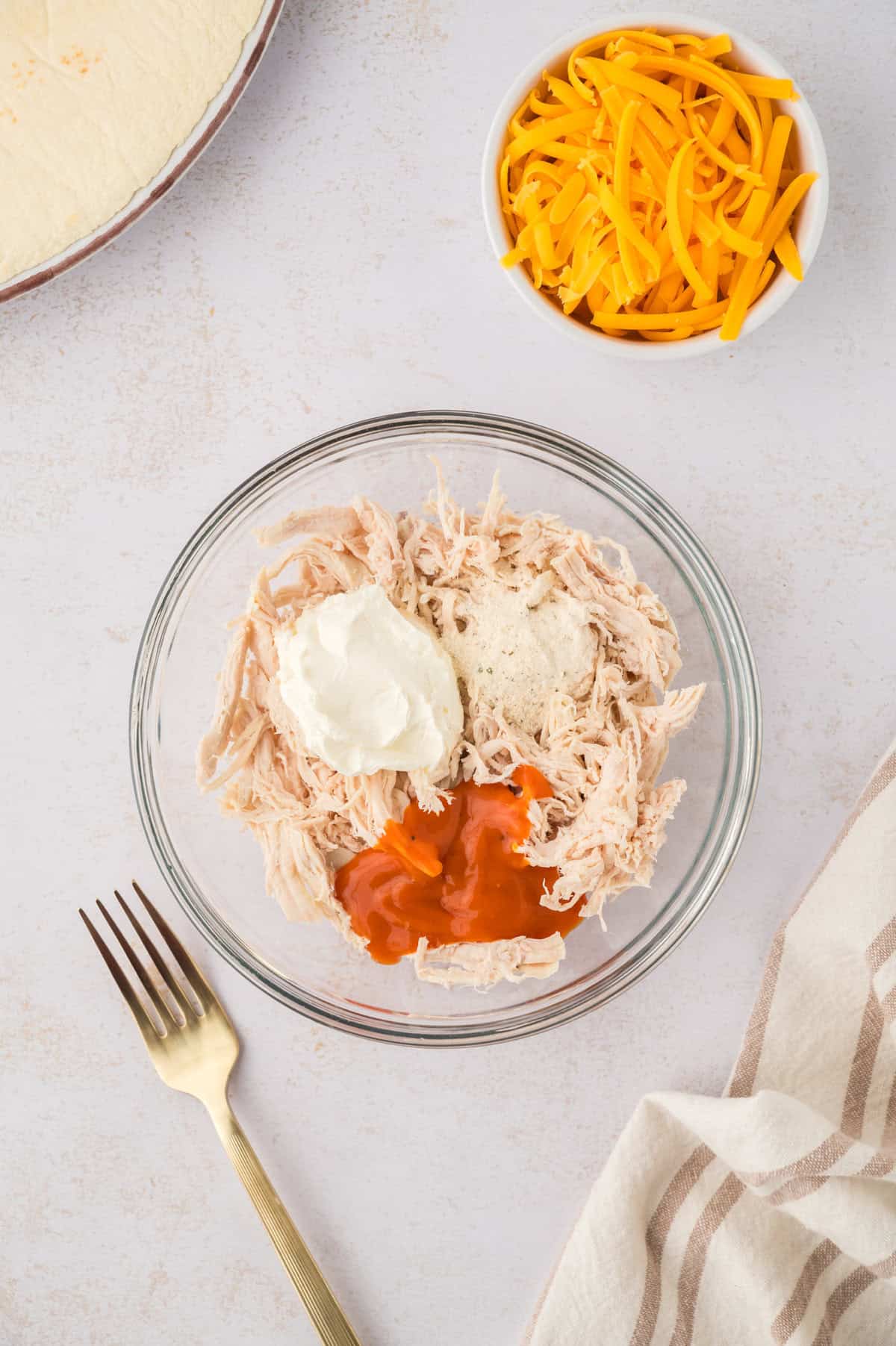 Chicken, cream cheese, and buffalo sauce in mixing bowl.