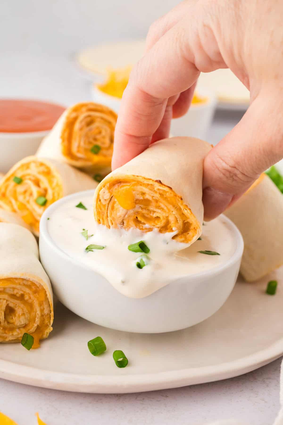 Buffalo chicken pinwheel being dipped in ranch dressing.