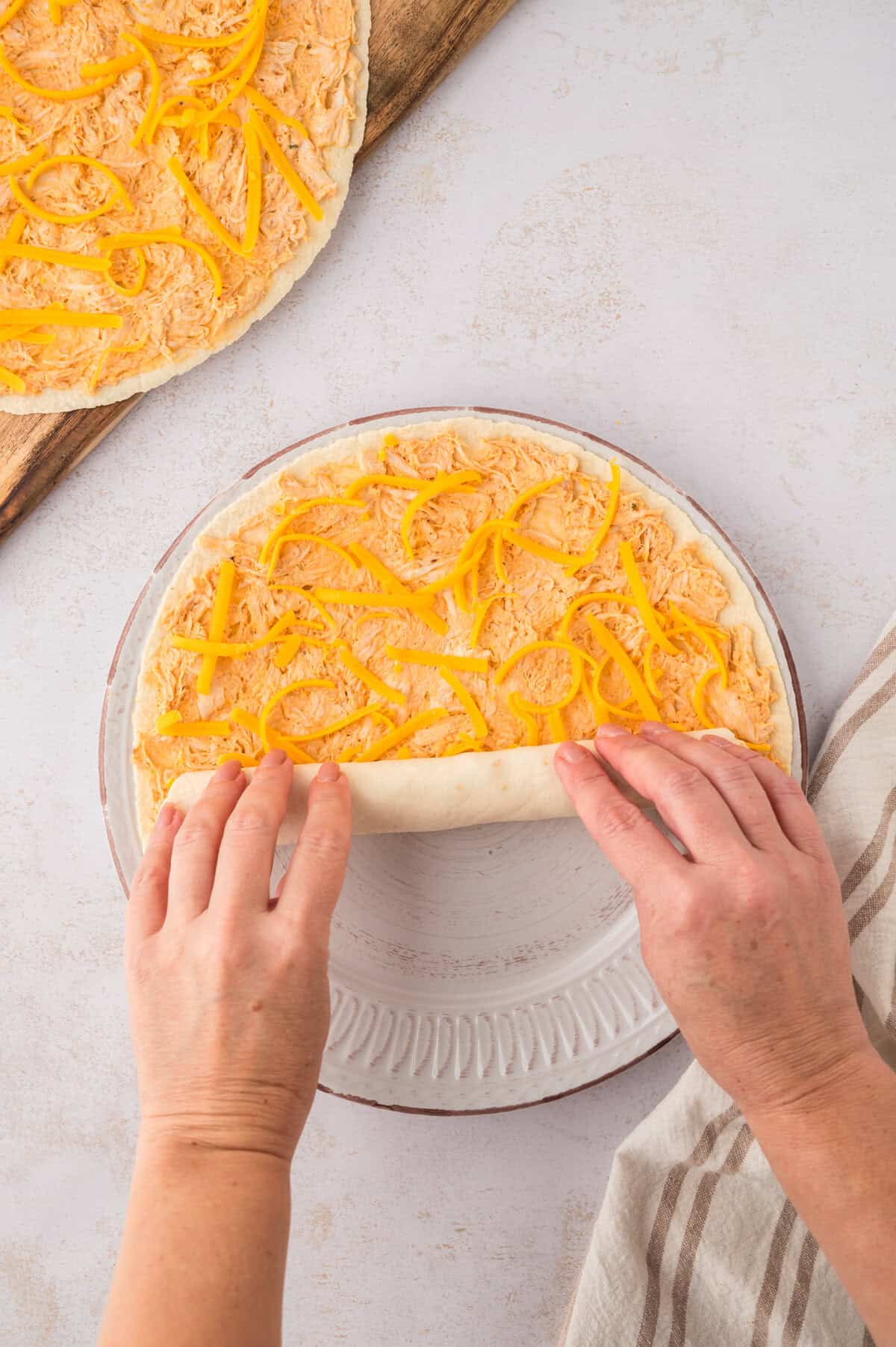Tortilla being rolled up to create pinwheels.