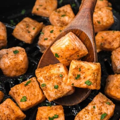 Cooked salmon bites in air fryer basket.