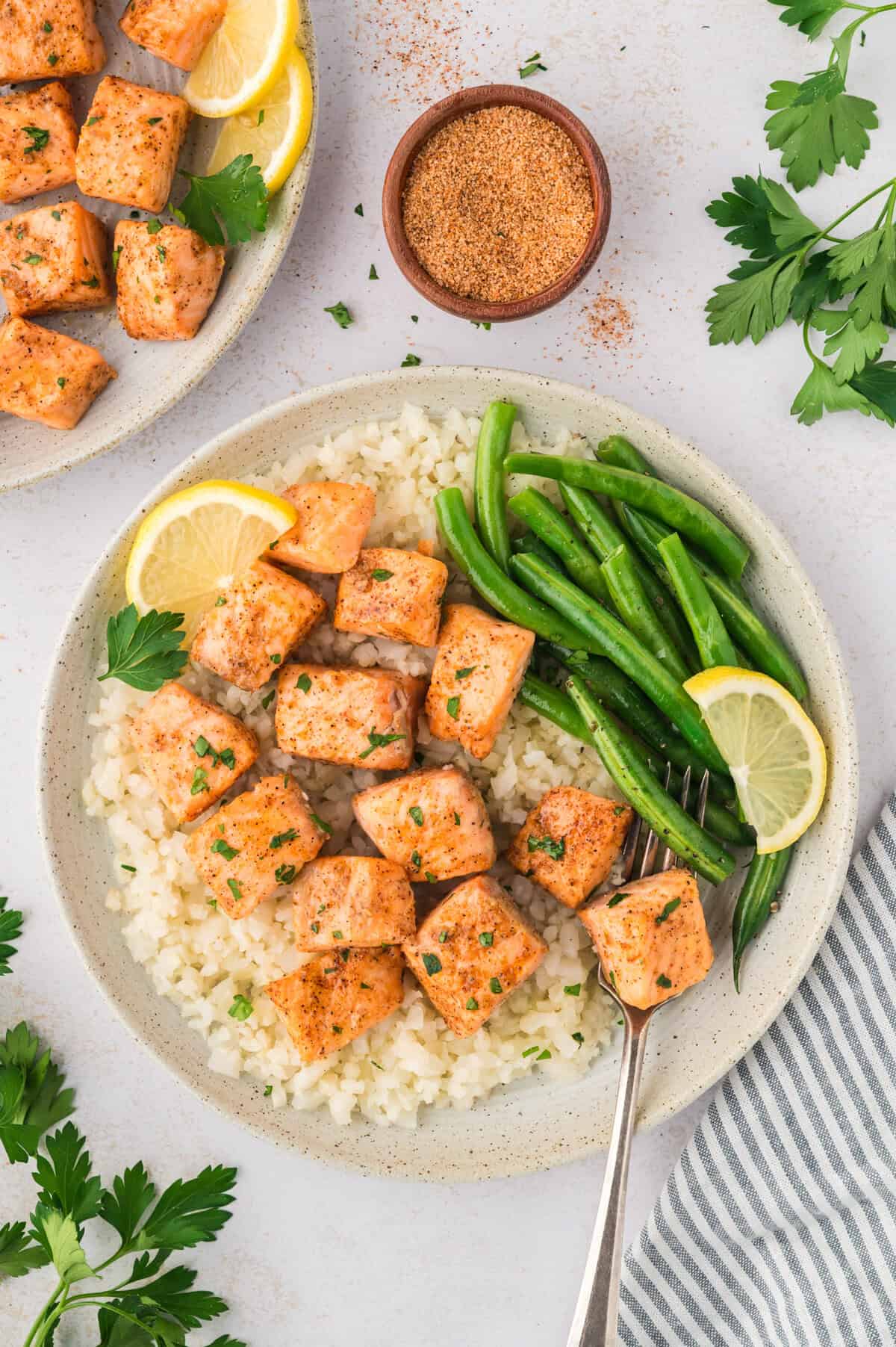 Cajun salmon bites, green beans, and cauliflower rice on plate.
