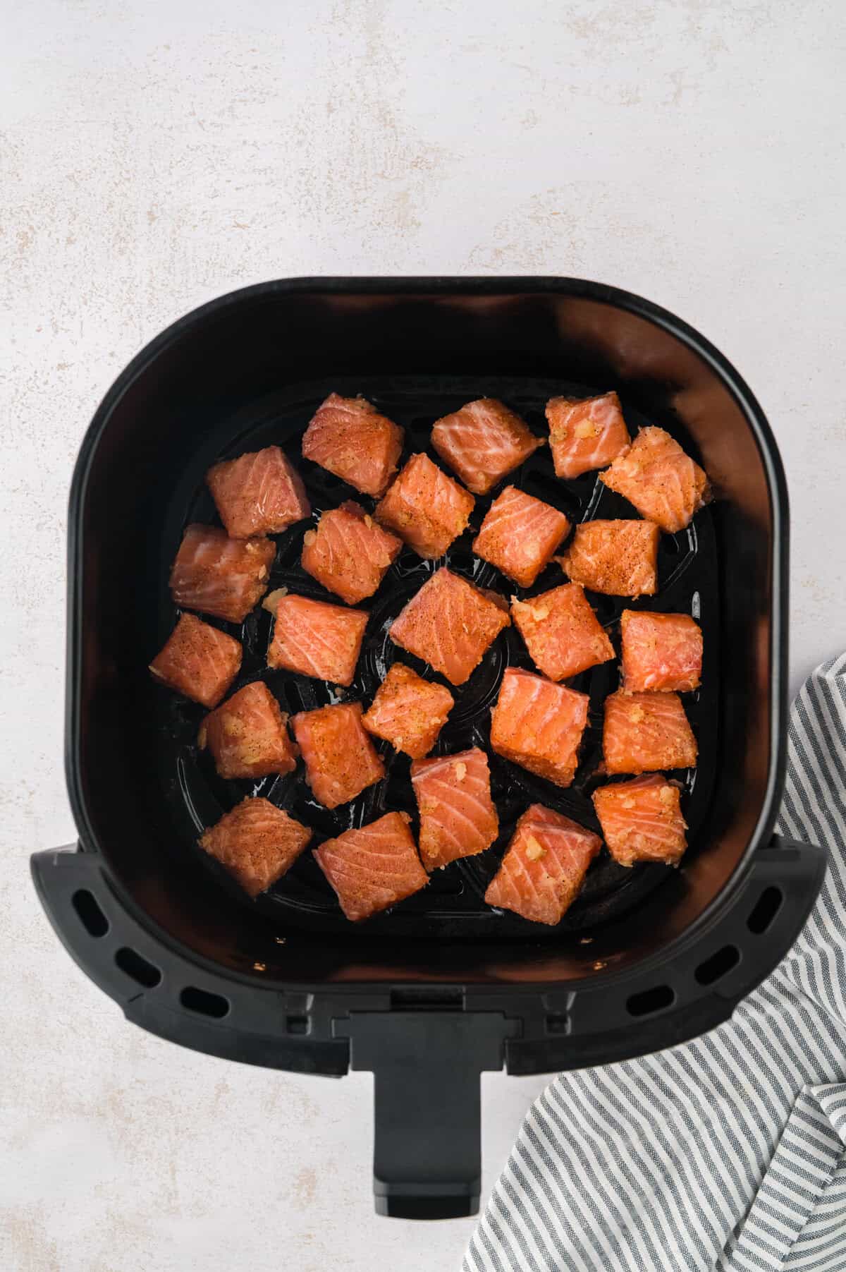 Keto salmon bites in air fryer basket.