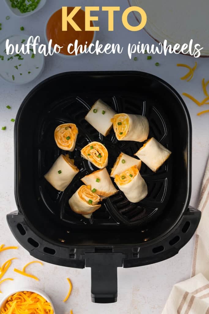 Air fryer basket filled with crispy buffalo chicken pinwheels made with low carb tortillas.