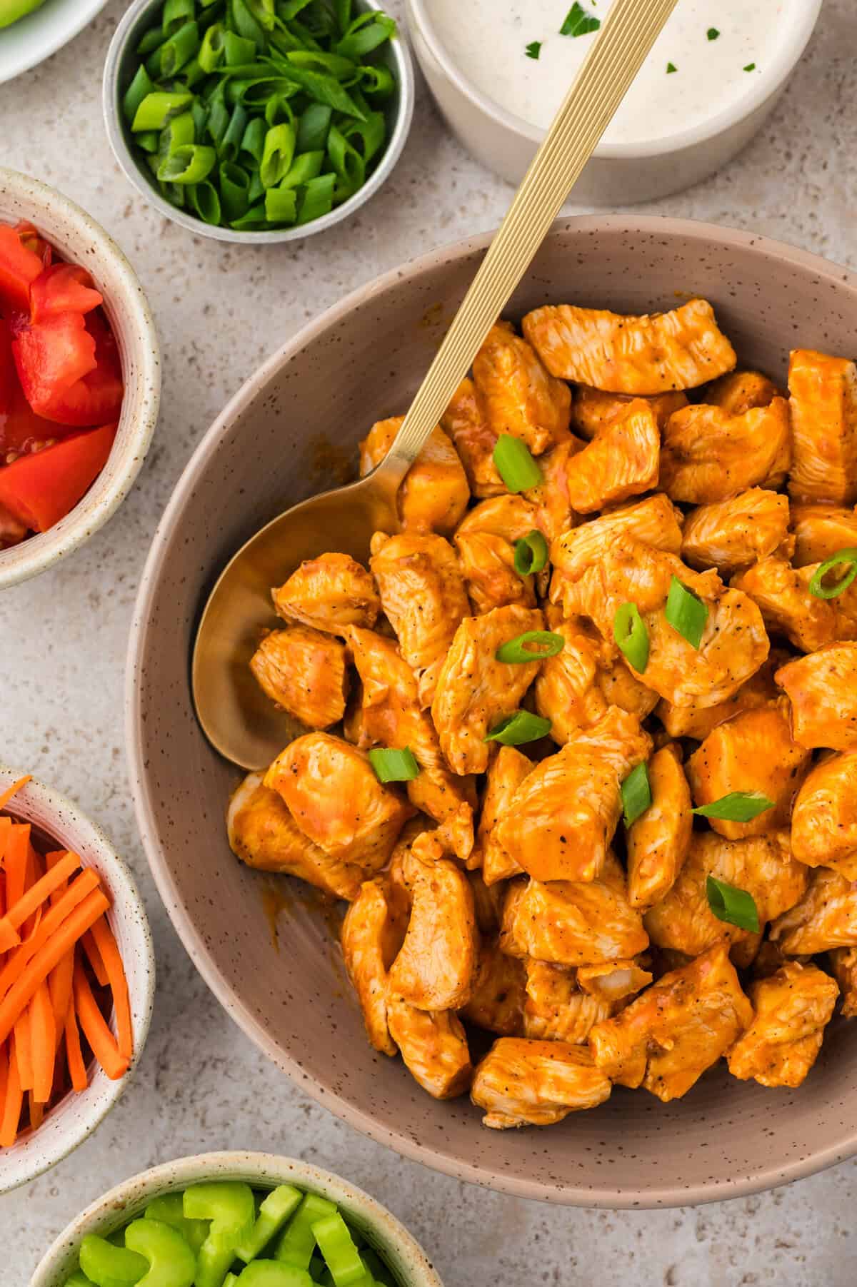 Bowl full of chicken bites tossed in buffalo sauce.