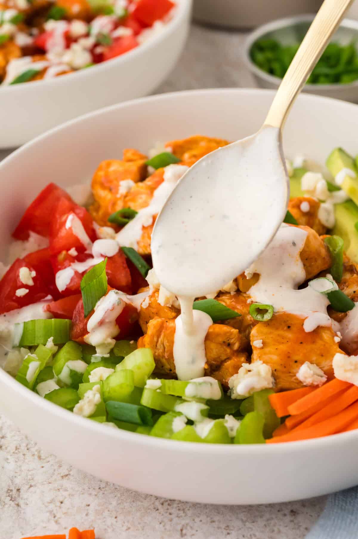 Ranch being drizzled over a keto chicken buffalo bowl recipe.