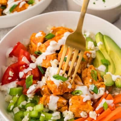 Fork grabbing a bite of buffalo chicken out of a bowl.