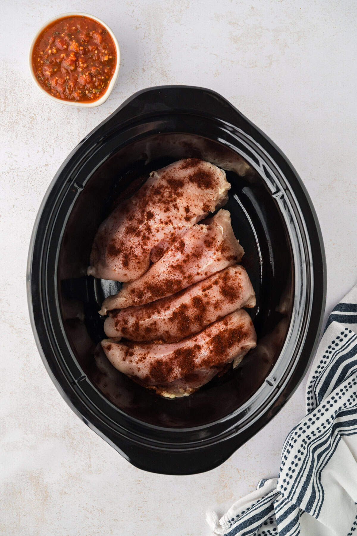 Chicken and seasoning in crockpot.