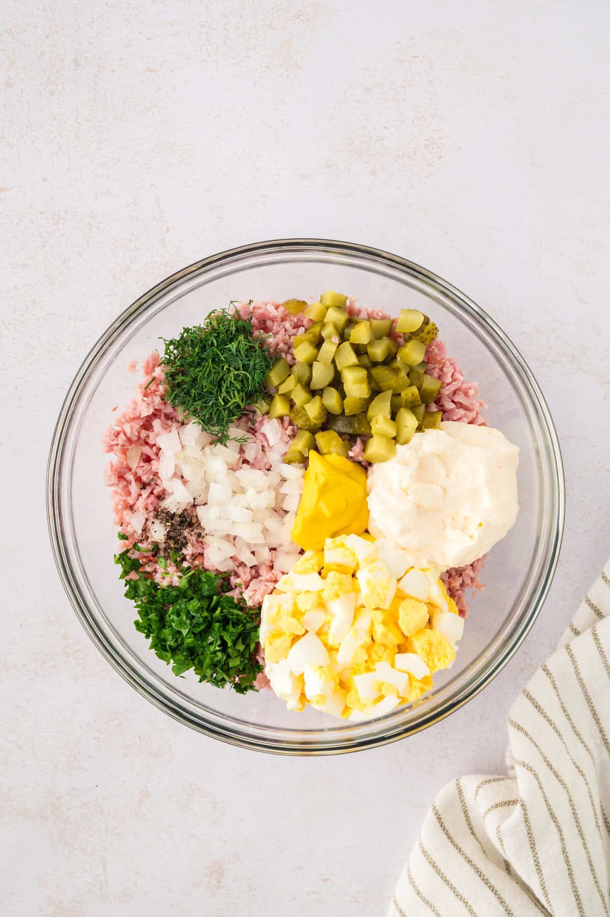 Ingredients for dill pickle ham salad in glass mixing bowl.