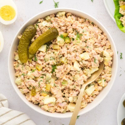 Overhead view of dill pickle ham salad in white bowl.
