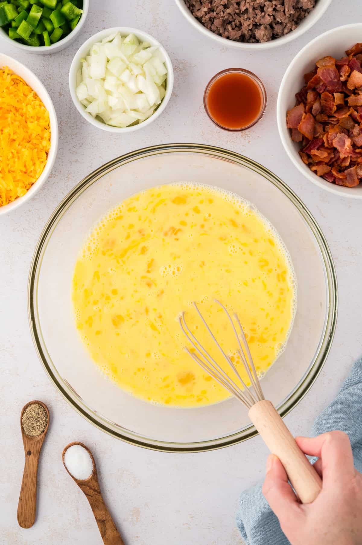 Eggs being whisked together in glass bowl.