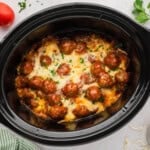 Slow cooker full of cheesy meatballs.