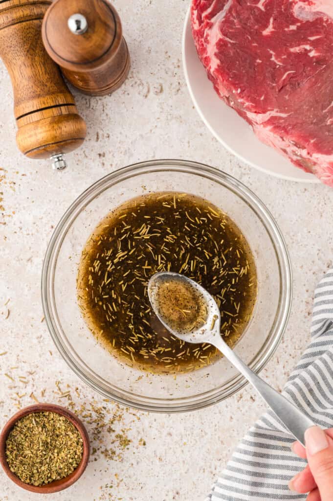 Steak marinade in bowl with spoon.
