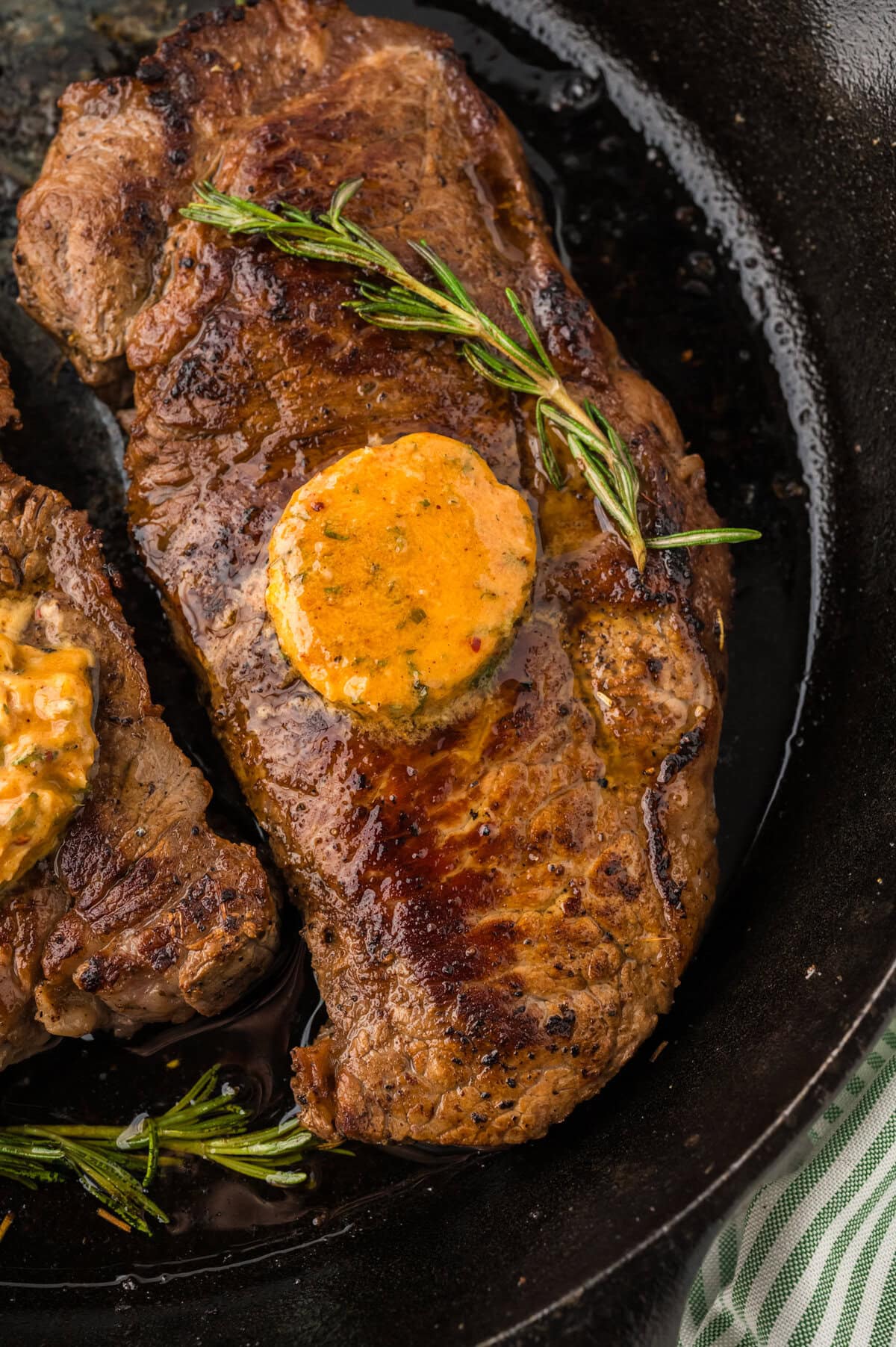 Pat of cowboy butter melting on a steak.