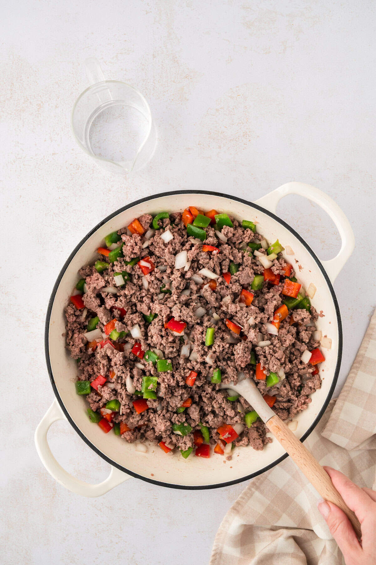 Peppers and onions in skillet with ground beef.