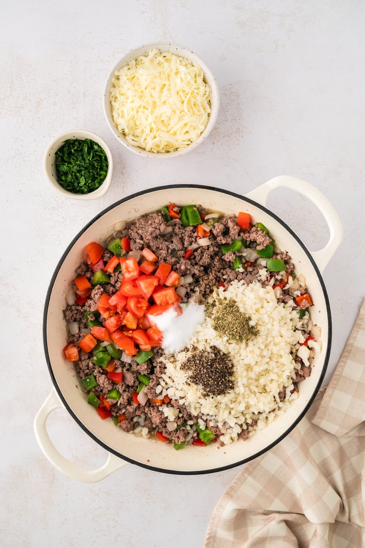 Vegetables added to beef in skillet.