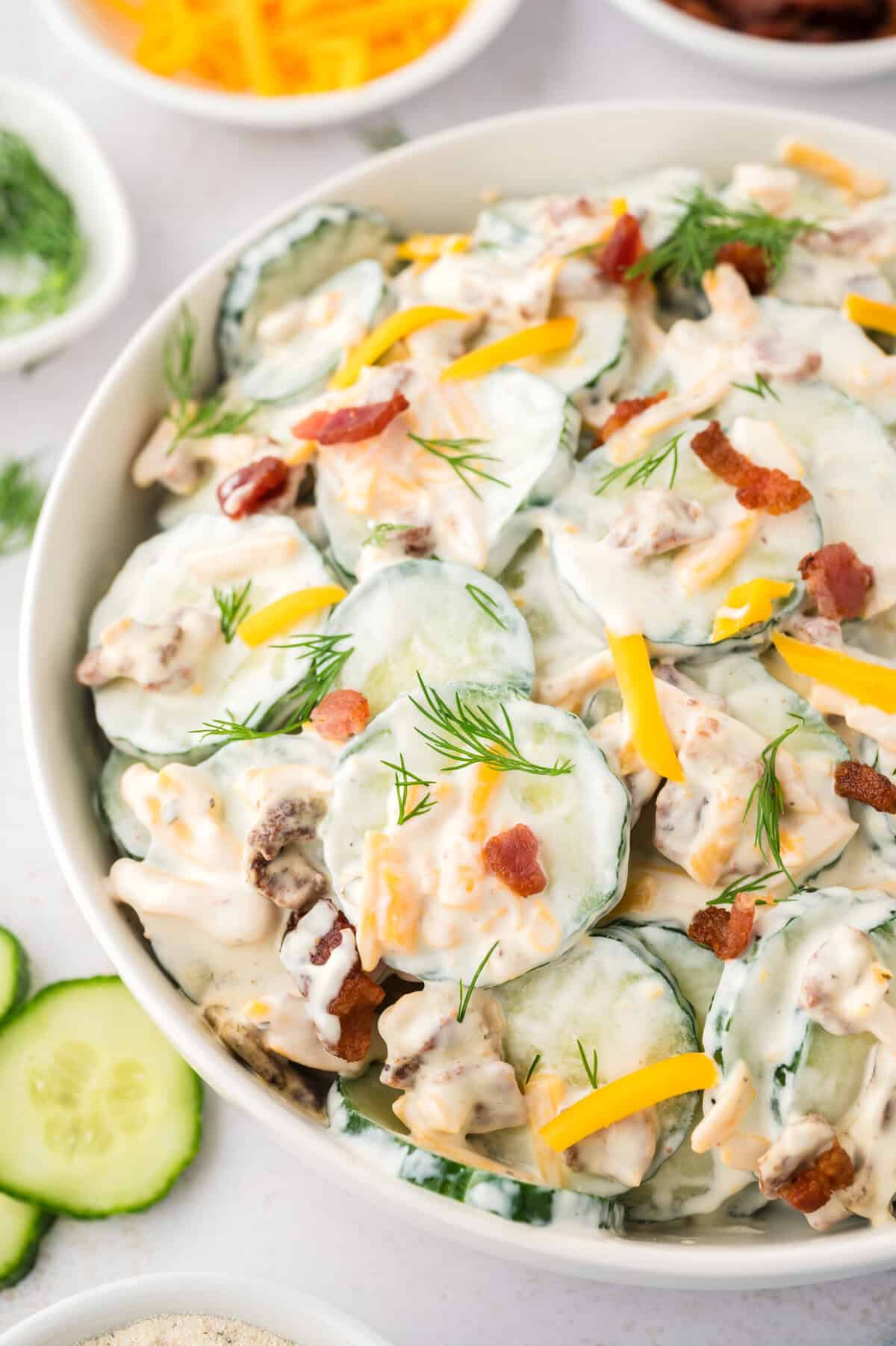 Crack cucumber salad in white serving dish.