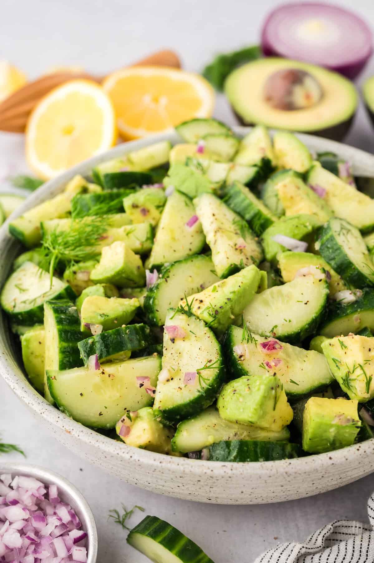 Avocado cucumber salad recipe in white serving dish.
